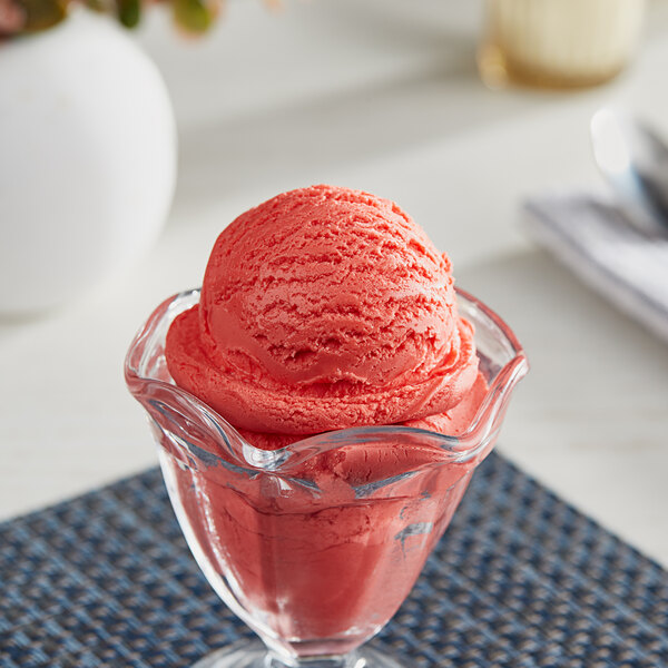 A glass cup with a scoop of I Rice Watermelon hard serve ice cream.