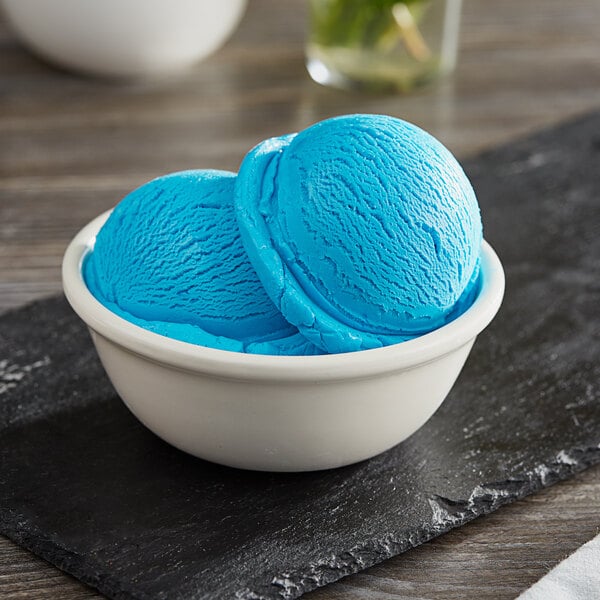 A bowl of I. Rice Blue Raspberry hard serve ice cream on a white background.
