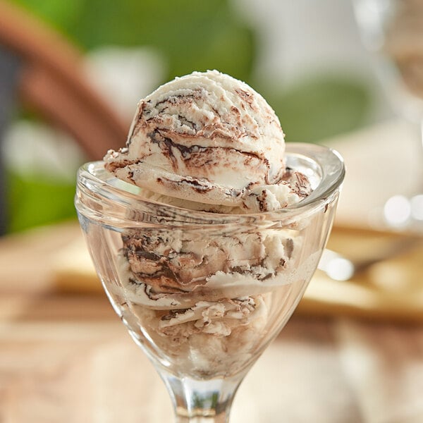A glass cup filled with chocolate variegated ice cream.