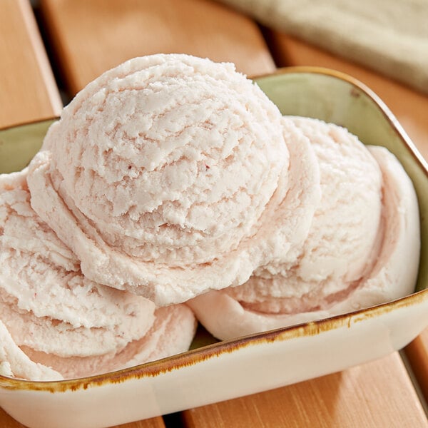 A bowl of I. Rice strawberry hard serve ice cream with three scoops.