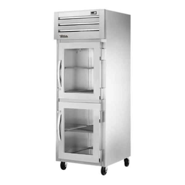 A True silver reach-in freezer with glass half doors.