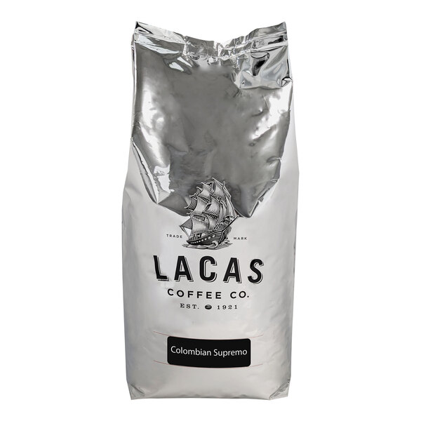 A silver bag of Lacas Coffee Colombian Supremo Whole Bean Coffee with a logo.
