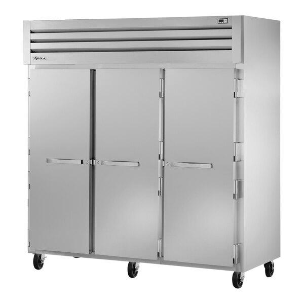 A large silver True Spec Series reach-in refrigerator on wheels.