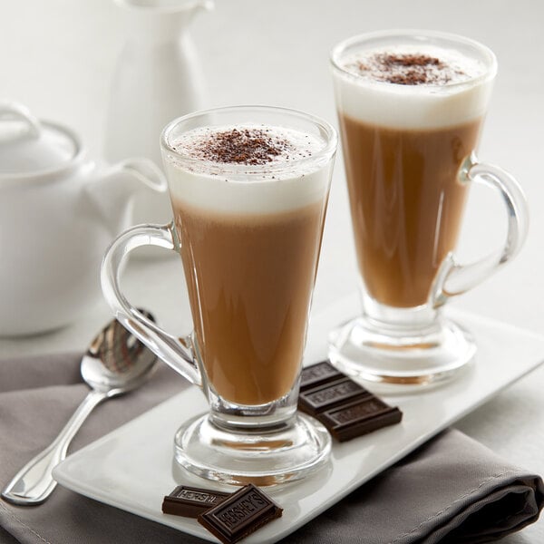 A glass of hot chocolate made with HERSHEY'S Cocoa on a white background.