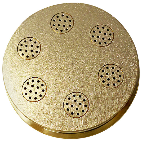 A circular gold pasta die with holes.