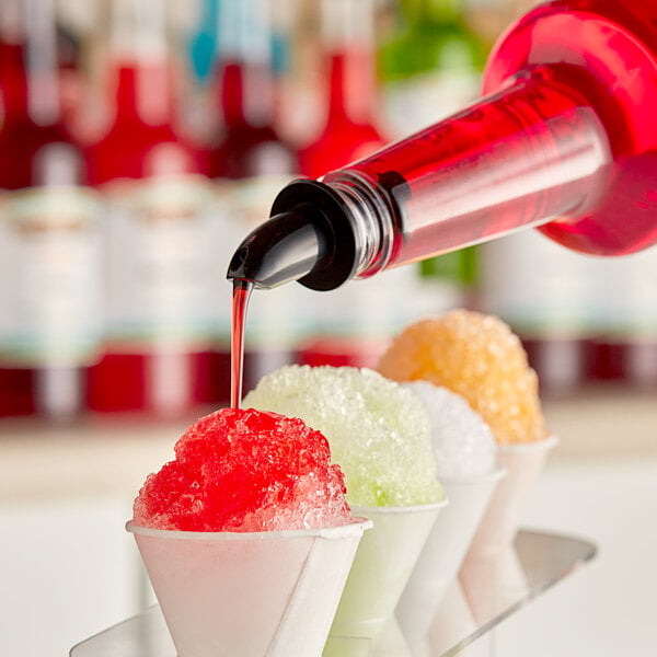 A bottle of Hawaiian Shaved Ice Bahama Mama syrup being poured over a cup of ice.