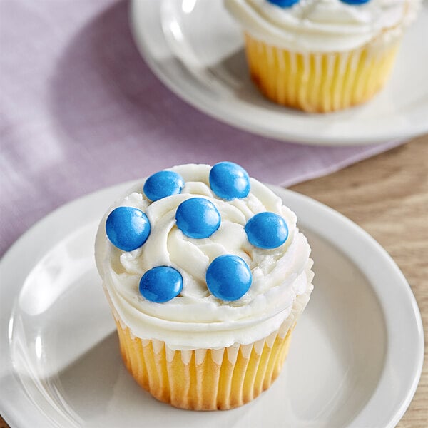 A close up of a cupcake with Blue Milk Chocolate Gems on top.