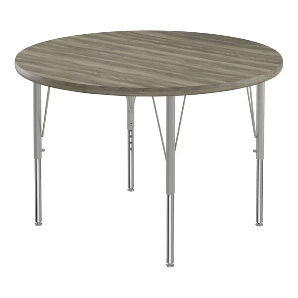 A Correll round activity table with metal legs and a driftwood gray top.