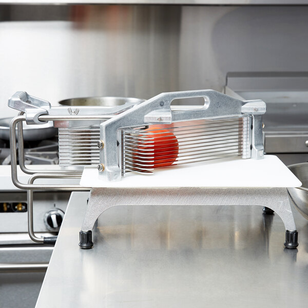 A Vollrath Tomato Pro tomato slicer on a kitchen counter.