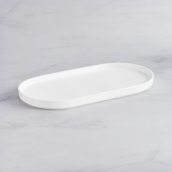 An Acopa Lore bright white rectangular porcelain platter with raised rims.
