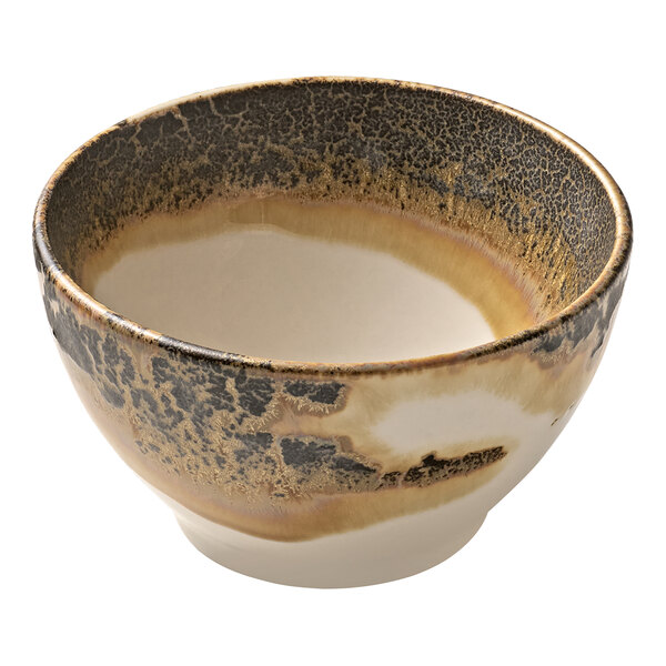 A white porcelain bowl with brown and black speckles on it.