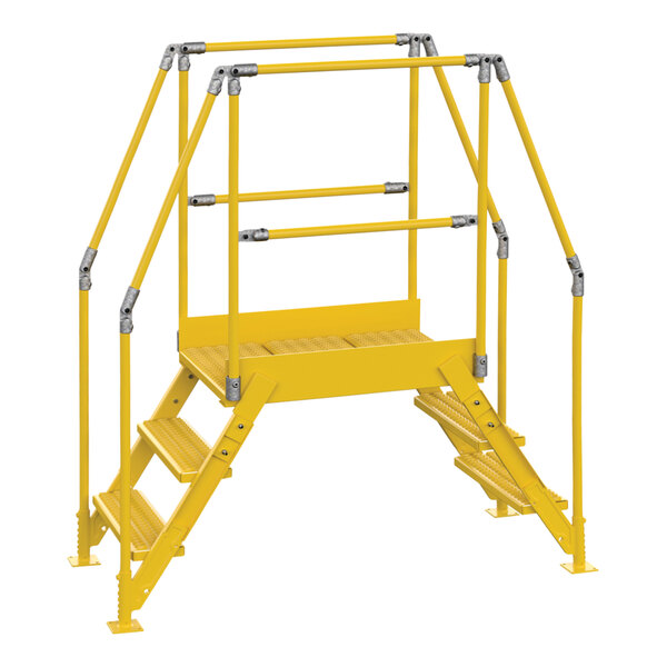 A yellow metal Vestil crossover ladder with metal bars on the steps.