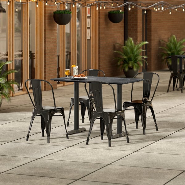Lancaster Table & Seating Excalibur 27 1/2" x 47 3/16" Rectangular Smooth Letizia Standard Height Table with 4 Alloy Series Black Outdoor Cafe Chairs
