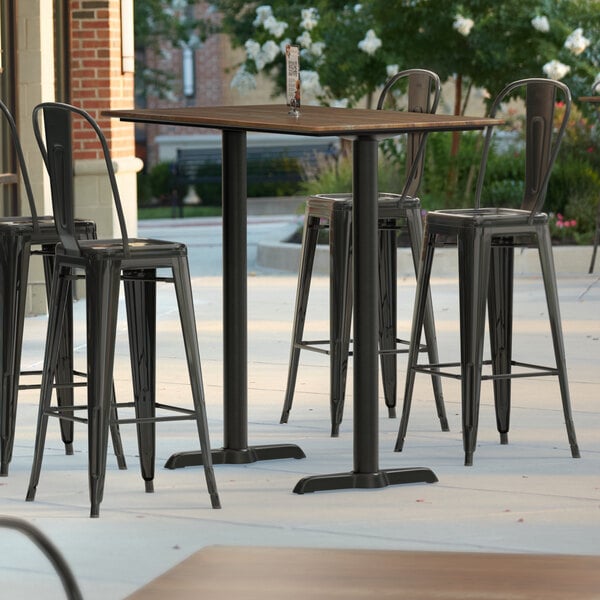 Lancaster Table & Seating Excalibur 27 1/2" x 47 3/16" Rectangular Textured Yukon Oak Bar Height Table with 4 Alloy Series Black Outdoor Cafe Barstools