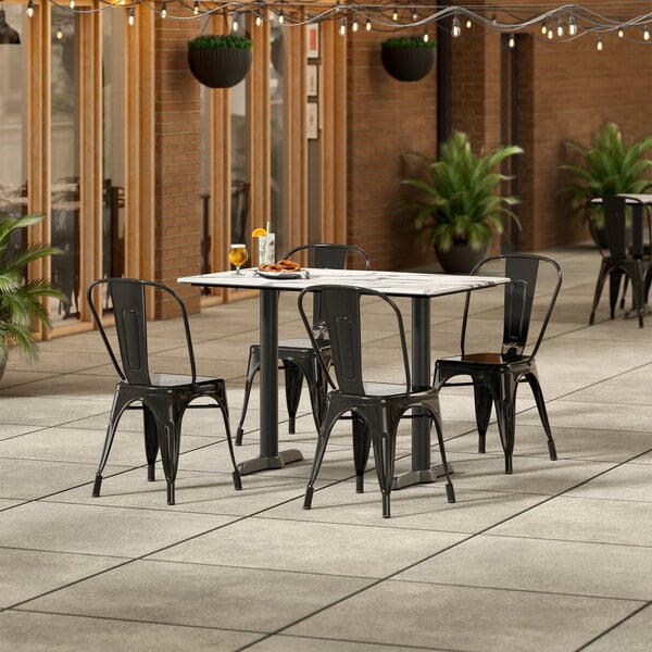 Lancaster Table & Seating Excalibur 27 1/2" x 47 3/16" Rectangular Smooth Versilla Standard Height Table with 4 Alloy Series Black Outdoor Cafe Chairs