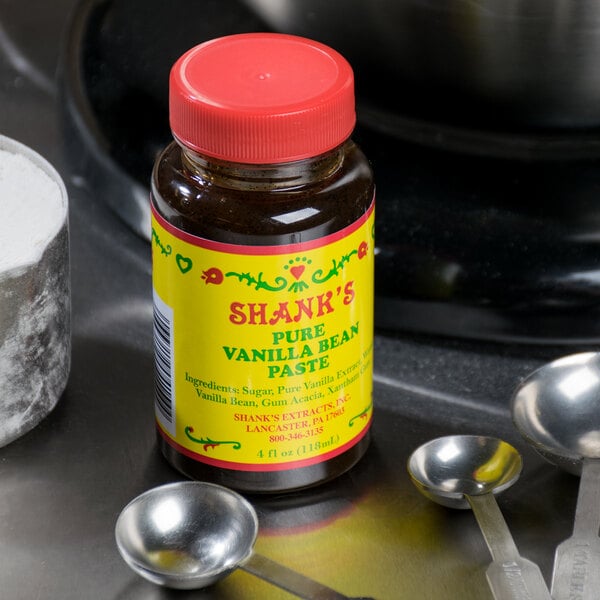 A jar of Shank's Vanilla Bean Paste next to measuring spoons.