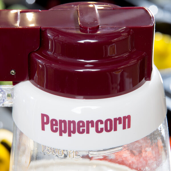 A white Tablecraft plastic salad dressing dispenser collar with maroon lettering on it.