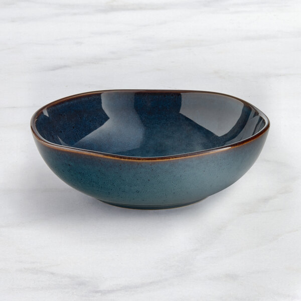 An Acopa Highlands skyfall blue china bowl on a marble surface.