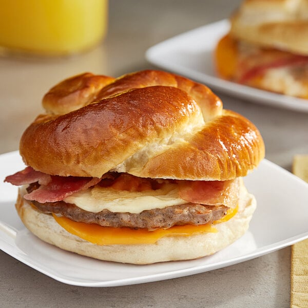 Grand Prairie Sausage, Bacon, and Cheese Pretzel Bun Sandwich 5.2 oz. - 24/Case