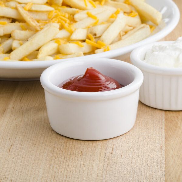 French fries and ketchup in Tuxton white ramekins.