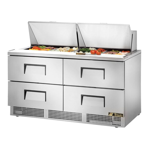 A True 4 Drawer Mega Top Refrigerated Sandwich Prep Table with food trays on the counter.
