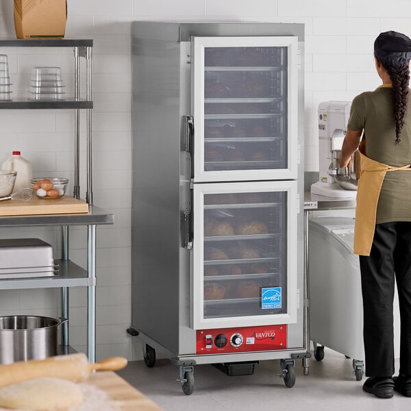 A full size vacuum-insulated heated holding cabinet with clear Dutch doors in a commercial kitchen setting.