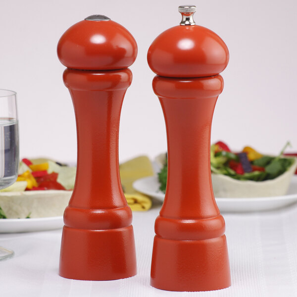 A Chef Specialties butternut orange pepper mill and salt shaker set on a table.