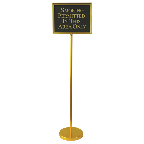 A gold Aarco hostess/teller sign on a long yellow pole with white text.