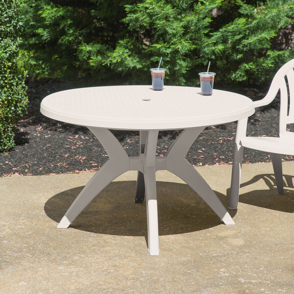 A white Grosfillex Ibiza table with a cup and straw on it.