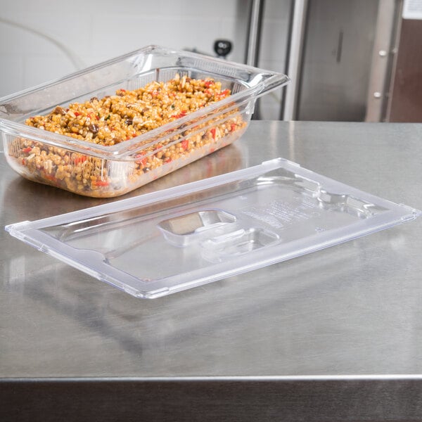 A Vollrath clear polycarbonate lid on a plastic food container with food in it.