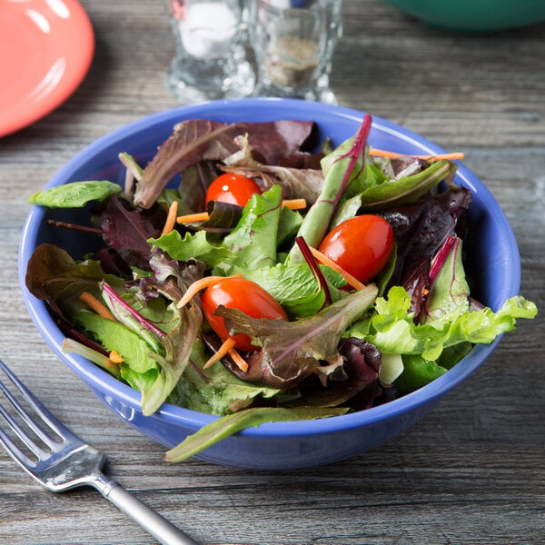 A GET Diamond Mardi Gras melamine bowl filled with salad with tomatoes, lettuce, and other vegetables with a fork next to it.