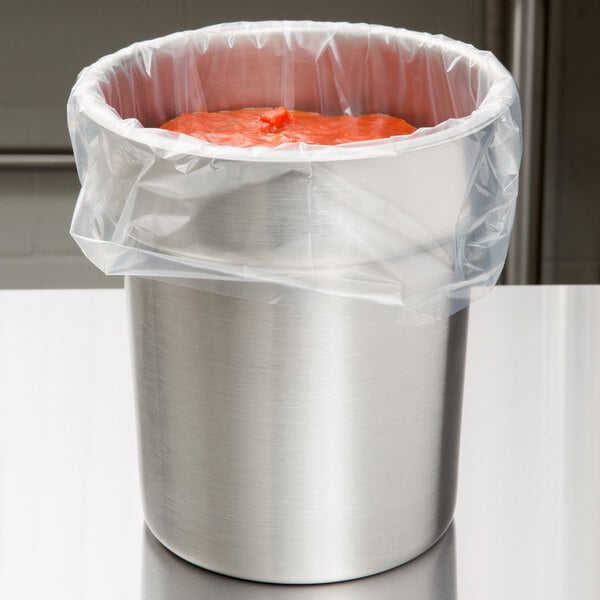 A Vollrath stainless steel vegetable inset in a silver container with red sauce inside.