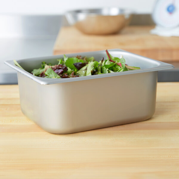 A stainless steel deli pan with salad in it on a counter.