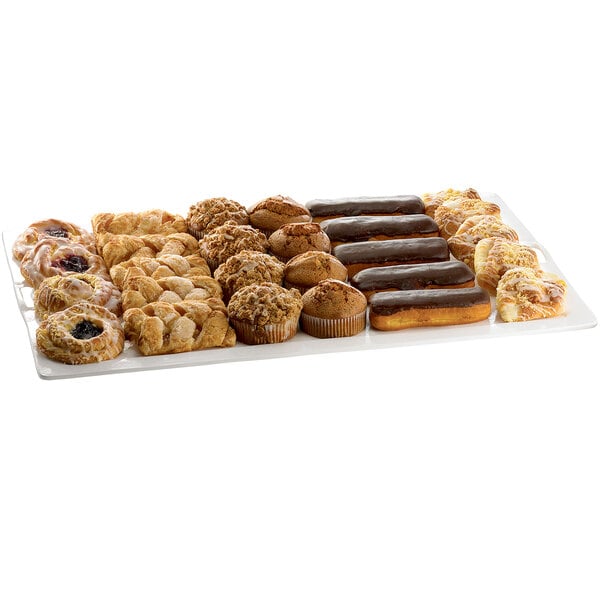 A Tablecraft white metal rectangular platter on a counter filled with assorted pastries.