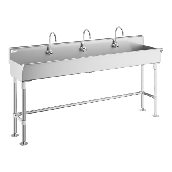 A large stainless steel sink with three gooseneck faucets and sturdy metal legs.