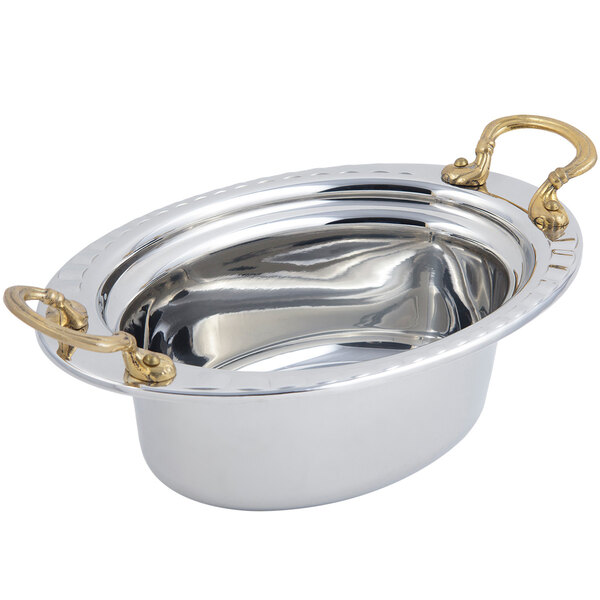 A large stainless steel Bon Chef oval food pan with brass handles.