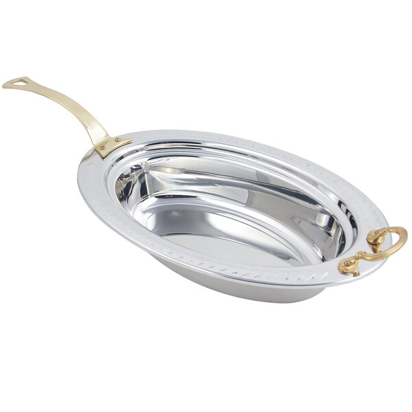 A stainless steel Bon Chef oval food pan with a long brass handle.