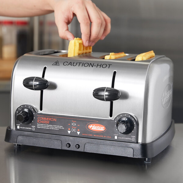 A person using a Hatco commercial toaster to make waffles.