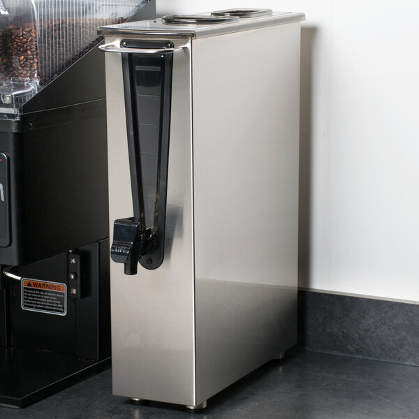 A Bunn 3.5 gallon narrow iced tea dispenser with a black handle next to a Bunn coffee maker.