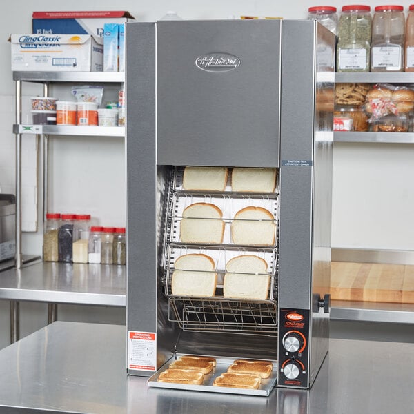 A Hatco vertical conveyor toaster with slices of bread on a rack.