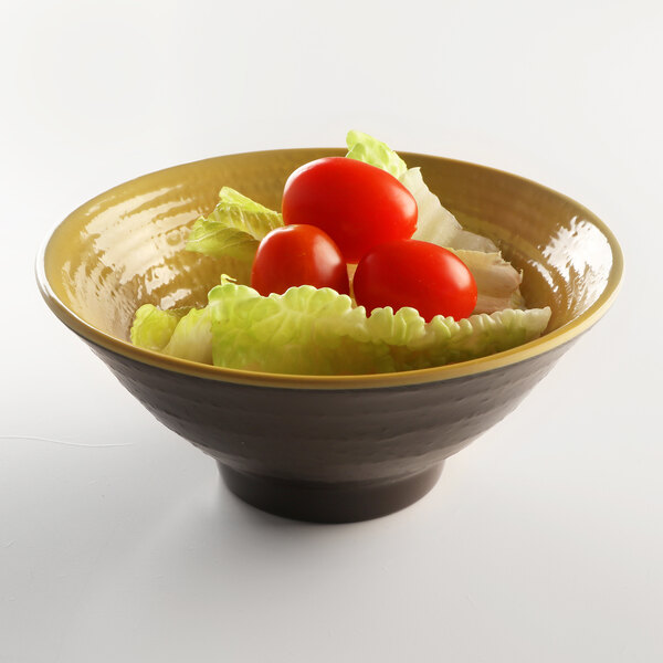 An Elite Global Solutions Pebble Creek olive oil-colored melamine bowl filled with a salad with tomatoes and lettuce.