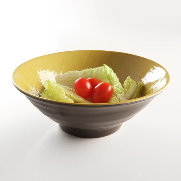 An Elite Global Solutions Pebble Creek olive oil-colored melamine bowl filled with lettuce and tomatoes.