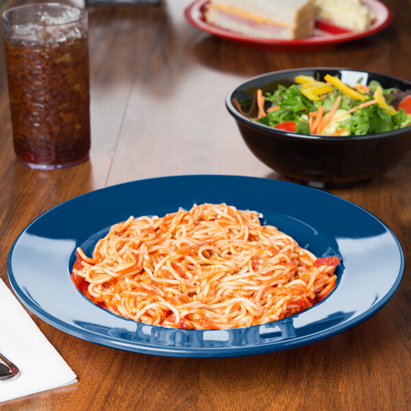 A bowl of pasta and salad on a blue table.