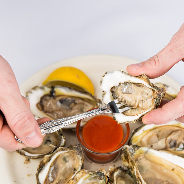 Oneida Rosewood stainless steel fork being used to eat an oyster.