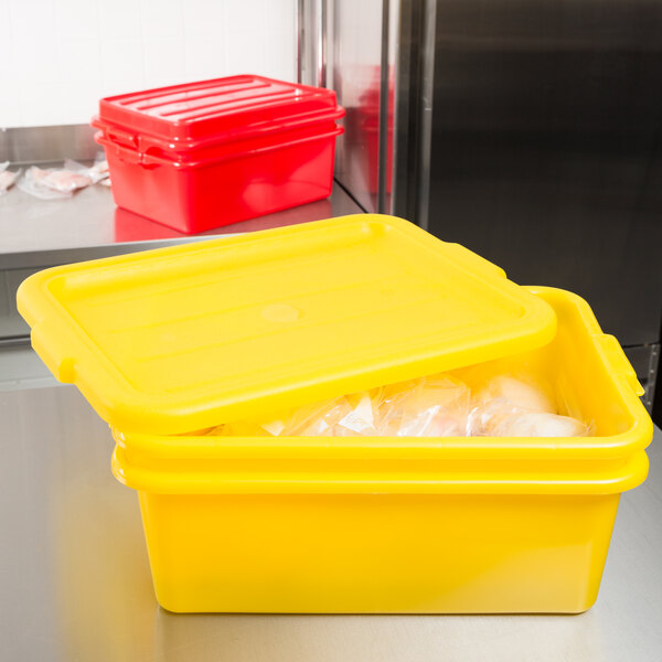 A yellow Vollrath Color-Mate food storage container with a lid on a counter.