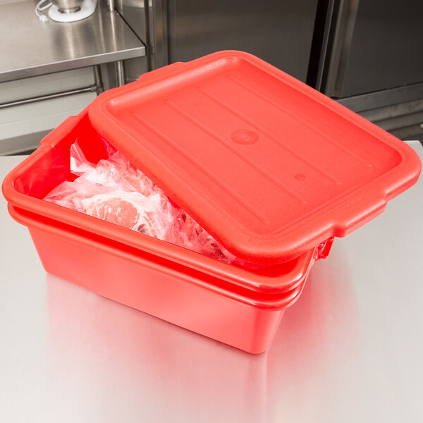 A red Vollrath Traex food storage container with a recessed lid on a counter.