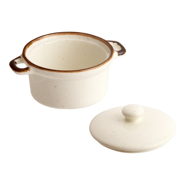 An 8 oz. vanilla bean porcelain mini casserole dish with a lid and two side handles.