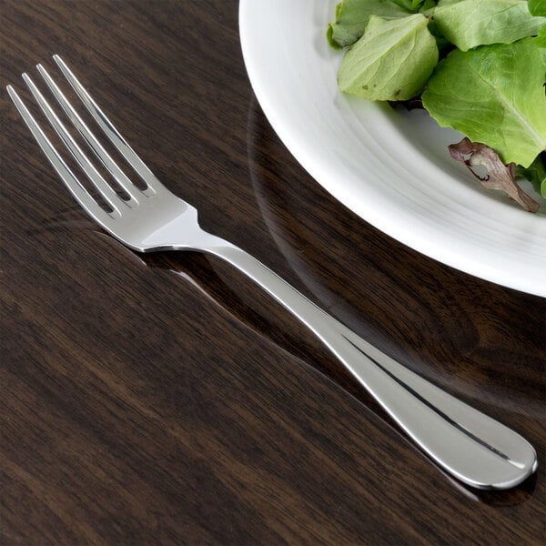 A Oneida stainless steel salad fork on a plate of salad.