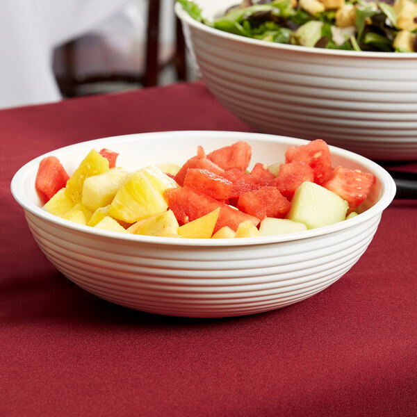 Two bowls of fruit salad in white Cambro ribbed bowls.