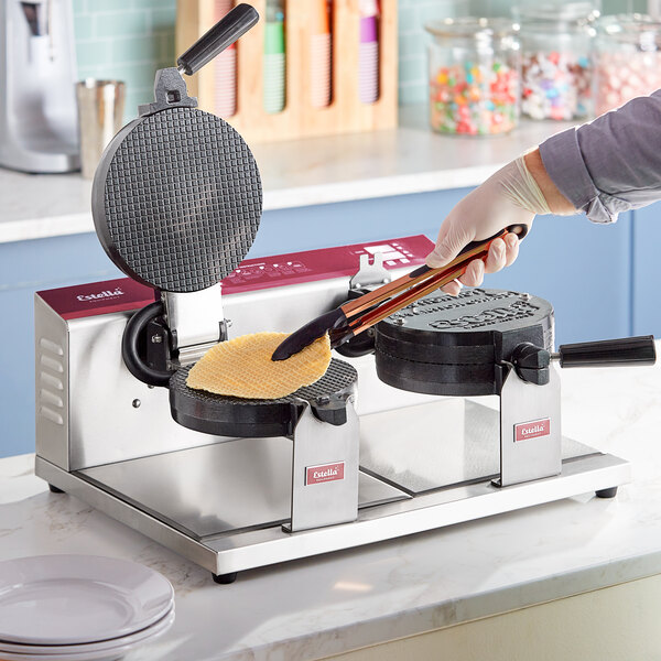 A double waffle cone maker with two round cooking plates, one open and one closed, on a stainless steel base.